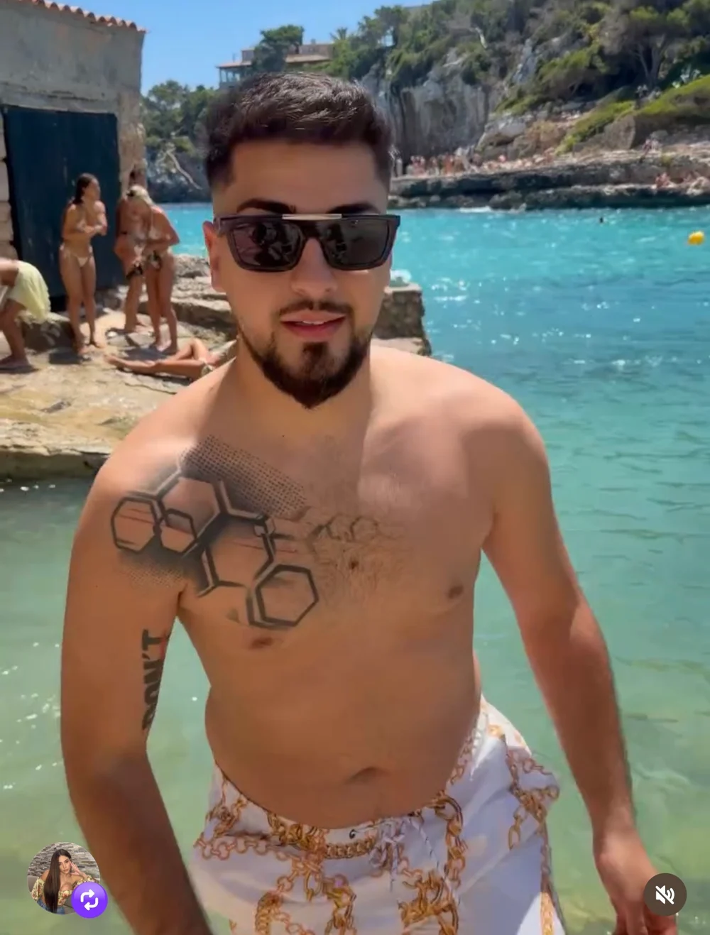 Patrick in sunglasses at a rocky turquoise cove